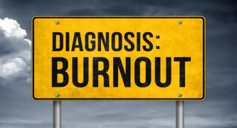 A yellow road sign with bold black text reading "DIAGNOSIS: BURNOUT" against a cloudy sky background, symbolizing mental exhaustion.
