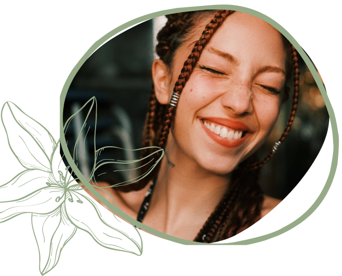 A close-up image of a woman with braided hair, wearing earrings, framed by a floral design, against a blurred background.
