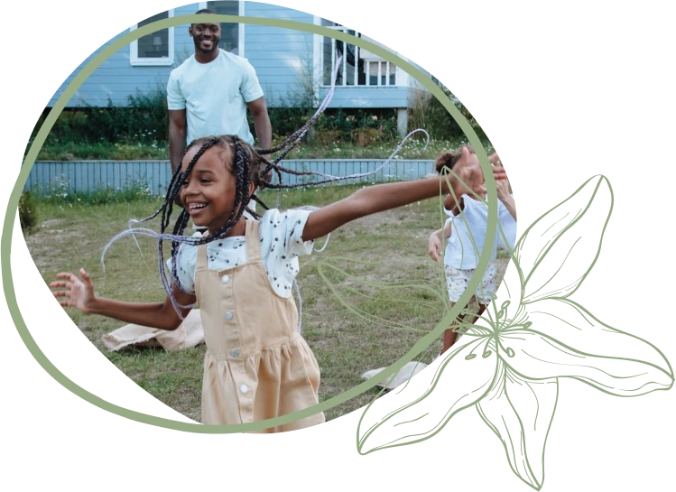 Children joyfully play outdoors with braids swaying, surrounded by green grass and a blue house in the background.
