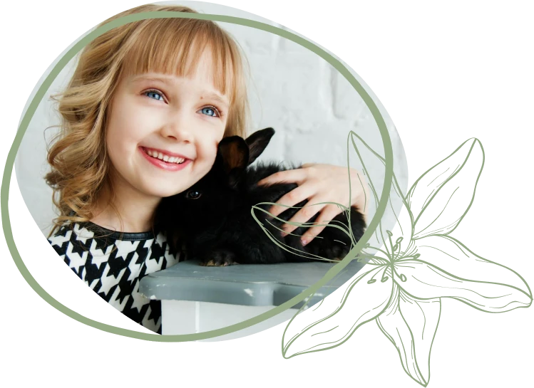 A person with wavy hair gently pets a black rabbit on a table, showcasing a moment of affection and companionship.