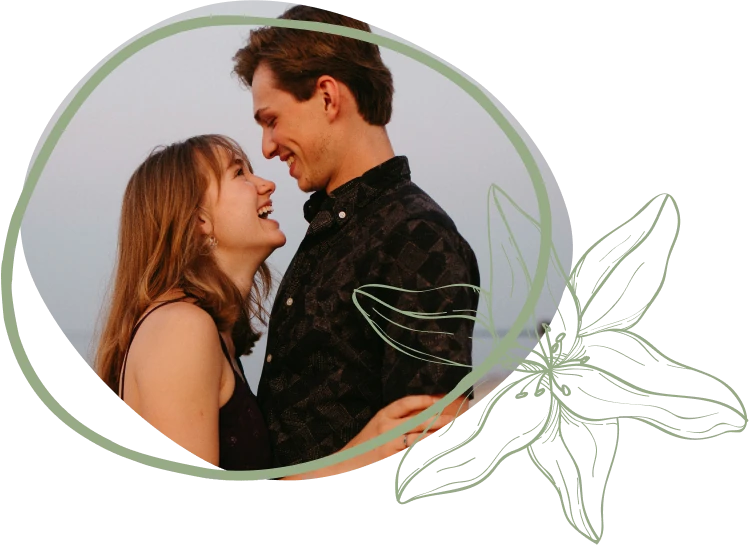 A couple leans in close, sharing an intimate moment against a soft, pastel background, framed by a delicate floral design.