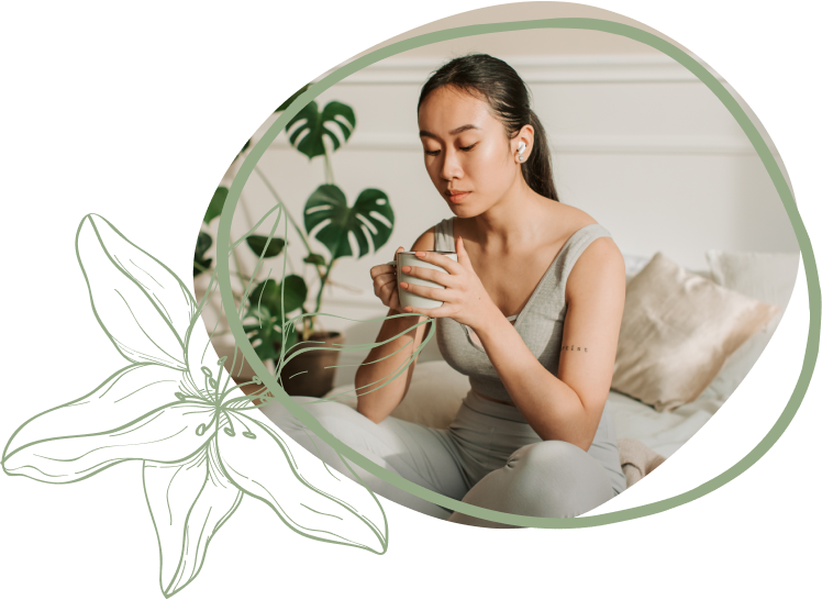 A person sits casually on a sofa, holding a cup, surrounded by indoor plants and soft pillows, creating a cozy atmosphere.