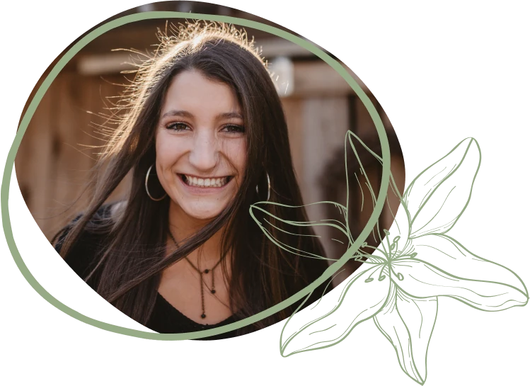A woman with long hair wearing hoop earrings and layered necklaces, framed by a circular outline with flower designs.