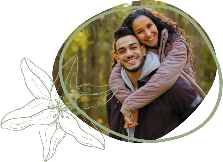 A woman joyfully gives a piggyback ride to a smiling man in a sunlit forest, surrounded by greenery and floral illustrations.